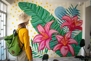 una mujer de pie frente a un mural de flores en HOSPEDAJE JOSUE - paracas, en Paracas 79 fotos más