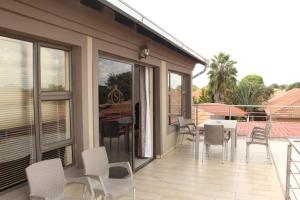 eine Terrasse mit Stühlen und einem Tisch auf einem Balkon in der Unterkunft Setumishi Royal Lodges in Ellisras
