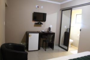 ein Wohnzimmer mit einem Kühlschrank und einem TV an der Wand in der Unterkunft Setumishi Royal Lodges in Ellisras