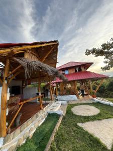 ein Resortgebäude mit Strohdach und Terrasse in der Unterkunft Wila House Rural in Gigante