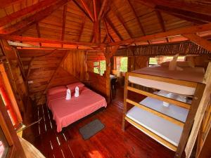 a room with two beds in a wooden cabin at Wila Hostal in Gigante