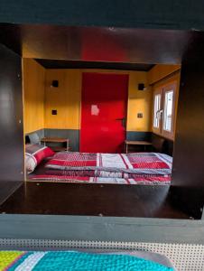 a bedroom with two beds in a room with a red wall at Oldtimer Camp Main Spessart in Collenberg