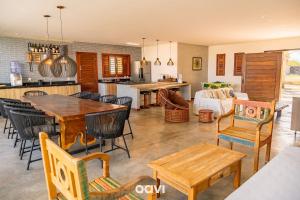 eine Küche und ein Wohnzimmer mit Tisch und Stühlen in der Unterkunft Casa Kairós no Shamballa by Qavi in São Miguel do Gostoso