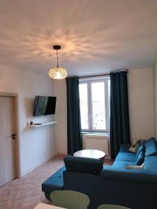a living room with a blue couch and a table at Appartement spacieux in Lille
