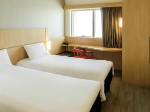 a hotel room with two beds and a window at ibis Cartagena Marbella in Cartagena de Indias +64 photos