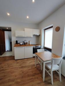 a kitchen with white cabinets and a wooden table at Duplex Central Eitorf in Eitorf