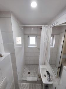 a white bathroom with a sink and a shower at Duplex Central Eitorf in Eitorf