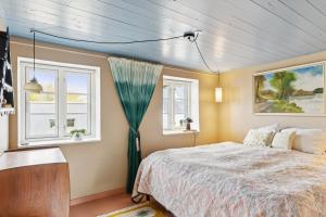 une chambre avec un lit et deux fenêtres dans l'établissement Stråtækt feriehusidyl ved vandet, à Sønderborg