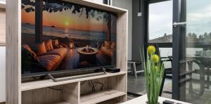 a living room with a flat screen tv on a entertainment center at Meloria Apartments in Veržej
