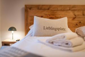 ヴァルヒゼーにあるApartment Fuchsbau - Natur, Ruhe, Geborgenheit - willkommen in Tirolのlitzhingspark と書かれた枕のあるベッド