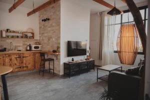eine Küche und ein Wohnzimmer mit Sofa und Fernseher in der Unterkunft רגע בזמן - Moment in time in Arad