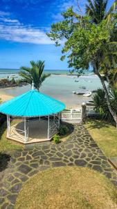 格兰高伯Picturesque Seafront Duplex - Seaview & Beach Access的海滩旁一座蓝顶凉亭