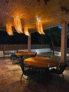 two tables and chairs under a wooden ceiling with lights at Villa Loui Beach Icaraizinho-Ce in Icaraí