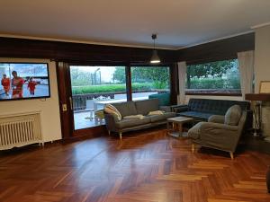 un salon avec un canapé et une télévision dans l'établissement Azkorri Beach House, à Getxo