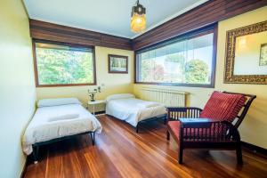 - une chambre avec deux lits, une chaise et une fenêtre dans l'établissement Azkorri Beach House, à Getxo 27 autres photos