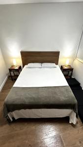 a bedroom with a large white bed with two lamps at Flat Pé na Areia em Angra dos Reis RJ in Angra dos Reis