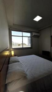 a large bed in a room with a window at Flat Pé na Areia em Angra dos Reis RJ in Angra dos Reis