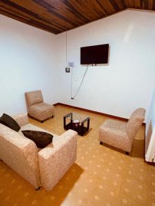 a living room with a couch and two chairs and a basketball hoop at Hospedaje Banhi in Líbano