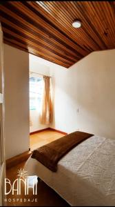a bedroom with a bed with a wooden ceiling at Hospedaje Banhi in Líbano