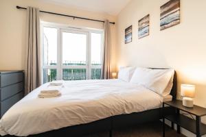 ein Schlafzimmer mit einem Bett und einem großen Fenster in der Unterkunft 2 Bedroom Flat - Harbour and Town Centre in Folkestone