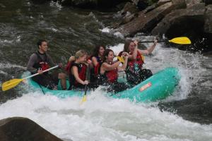 a group of people in a raft in a river at Cozy Cub Den, Chic Downtown Loft, Walk to Shops, Train, Restaurants in Bryson City +22 photos