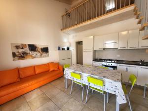 ein Wohnzimmer mit einem orangefarbenen Sofa, einem Tisch und Stühlen in der Unterkunft Residence Mediterranee Family Apartments in Lido di Jesolo