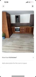 une cuisine avec des armoires en bois et une télévision dans une pièce dans l'établissement Sjøbergvegen23d, à Jessheim