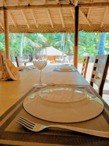 einen Tisch mit einem Teller und Weingläsern darauf in der Unterkunft Coco Cottage Kite Surfing-Kalpitiya in Kandakuli