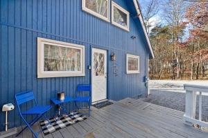 a blue house with two chairs and a door at Dog-Friendly Chalet in The Woods Resort w Fire Pit in Baxter