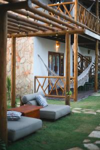 a patio with couches and a hammock in front of a house at Villa Loui Beach Icaraizinho-Ce in Icaraí