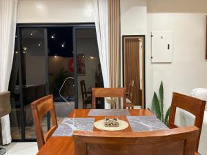 einen Esstisch und Stühle in einem Zimmer in der Unterkunft Humble Cocoon1-2BR Unit House Near Inflatable Island & Subic Bay Yacht in Subic