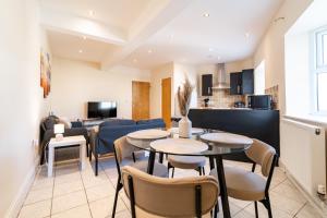 ein Wohnzimmer mit Tischen und Stühlen und einer Couch in der Unterkunft 2 Bedroom Flat - Harbour and Town Centre in Folkestone