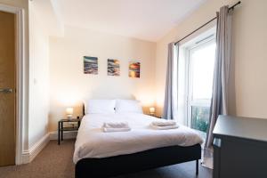 una camera da letto con un letto e una grande finestra di Stylish 2 Bed Flat with Free Parking near Harbour a Folkestone