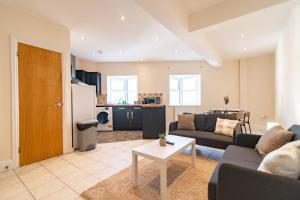 ein Wohnzimmer mit Sofa und Tisch in der Unterkunft 2 Bedroom Flat - Harbour and Town Centre in Folkestone