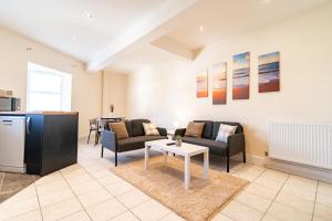 un soggiorno con un divano e un tavolo di Stylish 2 Bed Flat with Free Parking near Harbour a Folkestone