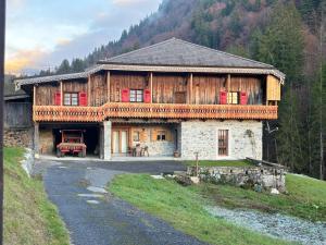 een groot houten huis in het midden van een berg bij La Ferme à Roger in Montriond