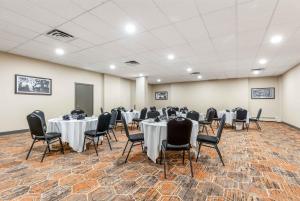 uma sala de conferências com mesas e cadeiras em Days Inn by Wyndham Airdrie em Airdrie