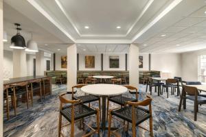 ein Esszimmer mit Tischen und Stühlen in einem Gebäude in der Unterkunft Fairfield Inn & Suites Memphis Olive Branch in Olive Branch