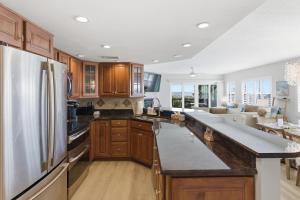 a kitchen with wooden cabinets and a stainless steel refrigerator at Bermuda Run 10 in Saint Augustine Beach