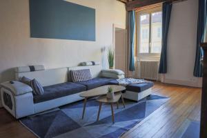a living room with a couch and a table at Les Haussmanniens in Pont-de-Vaux