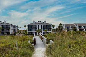 a walkway through the sand with houses in the background at Bermuda Run 10 in Saint Augustine Beach