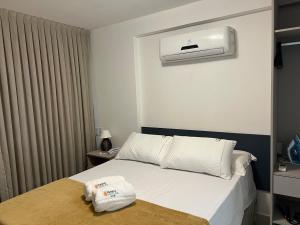 ein Schlafzimmer mit einem Bett und einer Klimaanlage an der Wand in der Unterkunft Puerto Ventura 403 · Puerto Ventura - Beira Mar na Orla de Cabo Branco in Tambaú