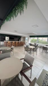ein großer Raum mit Tischen und Stühlen in der Unterkunft Puerto Ventura 403 · Puerto Ventura - Beira Mar na Orla de Cabo Branco in Tambaú