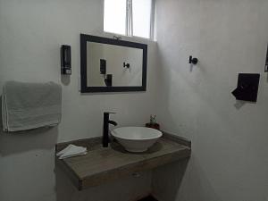 une salle de bain avec un lavabo et un miroir dans l'établissement Cómoda habitación, à Pátzcuaro