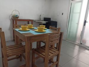 une table en bois avec quatre bols jaunes dessus dans l'établissement Cómoda habitación, à Pátzcuaro