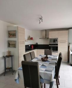 a kitchen with a table and some chairs and a table and a kitchen at Maison familiale Chinon in Chinon