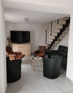 a living room with a couch and a tv and stairs at Maison familiale Chinon in Chinon