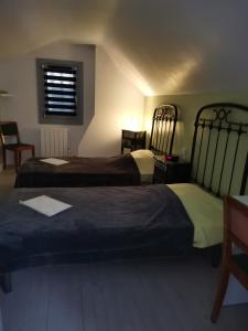 two beds in a hotel room with a window at Maison familiale Chinon in Chinon