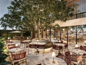 patio ze stołami, krzesłami i drzewem w obiekcie Berthas collection by em hotels w mieście Cartagena de Indias