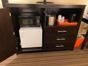 een keuken met een magnetron en een kleine koelkast bij Norwood Inn & Suites By BlissPoint in Indianapolis